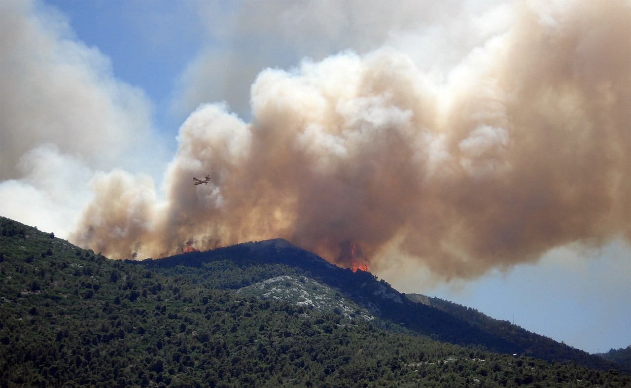 Smoke from a wildfire bellowing off the top or a ridgeline.