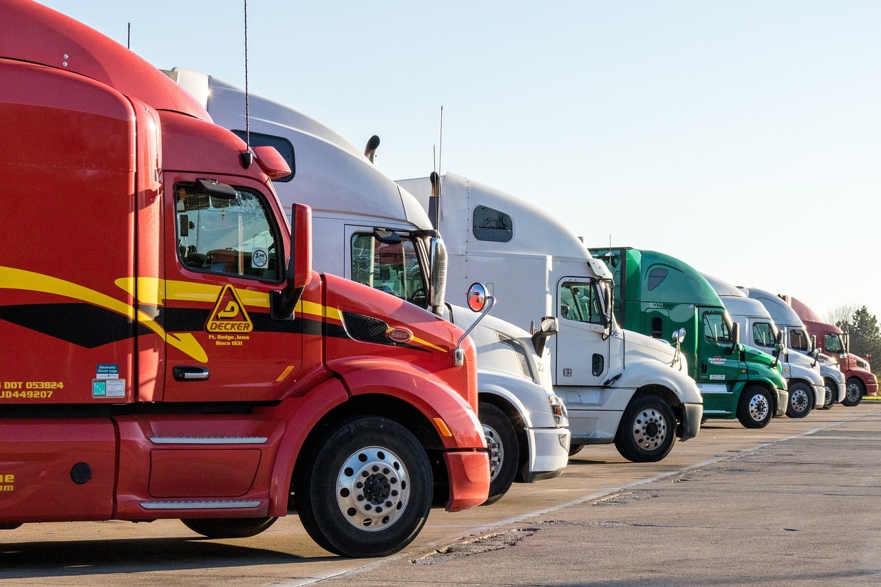 Semi-Truck Cabs lined up in a row in parking lot.