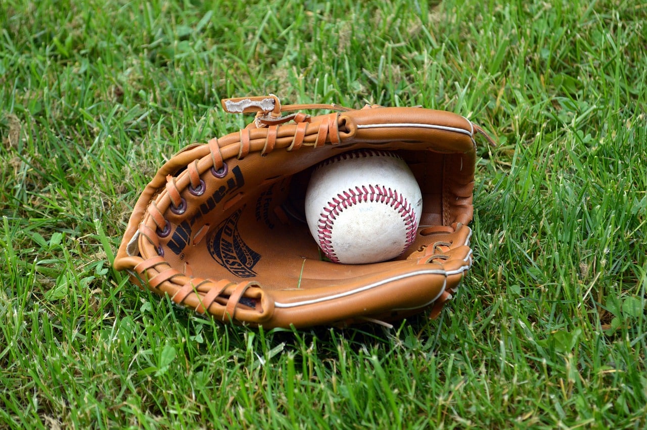 Baseball glove with baseball inside on grass