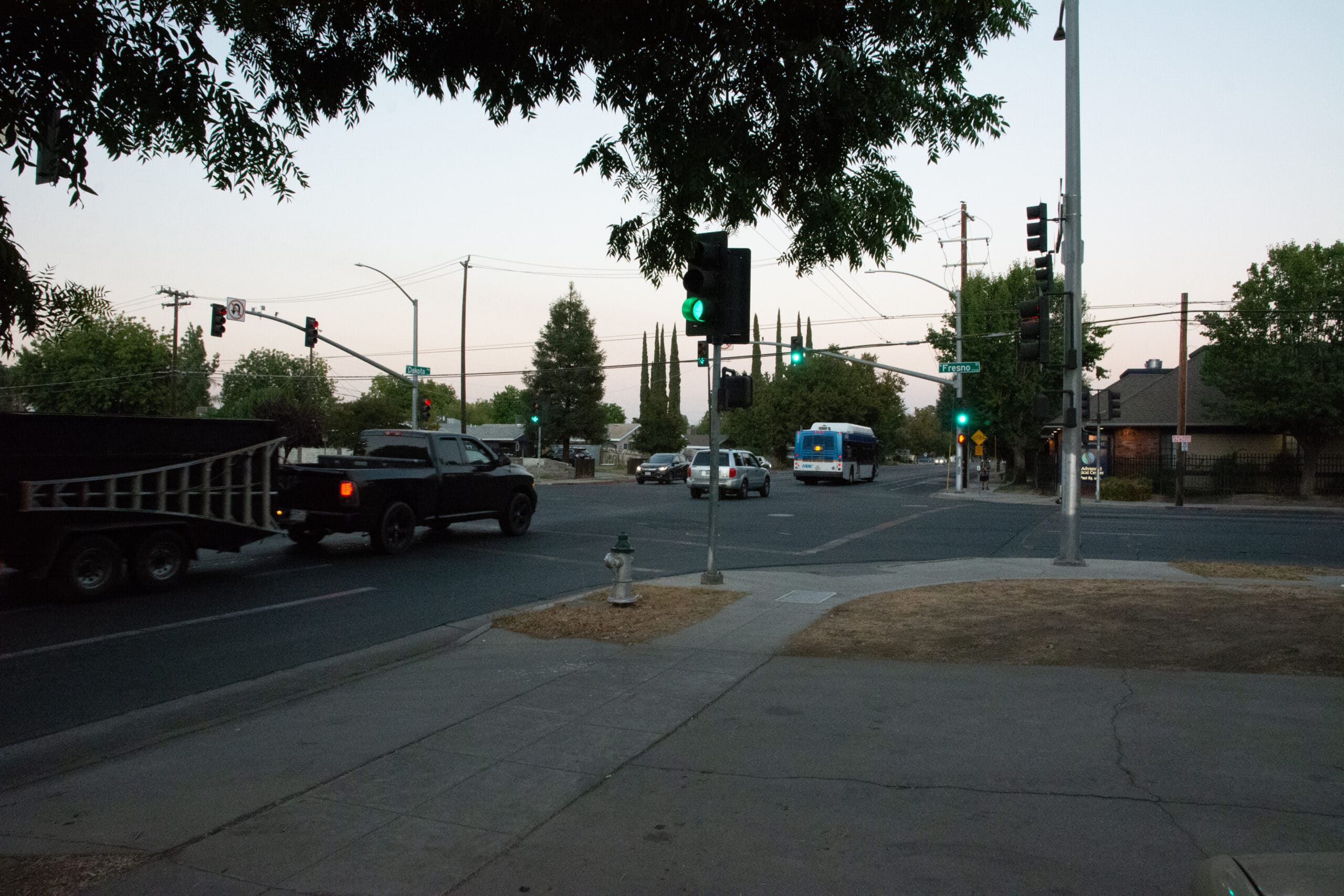 Traffic at intersection of Dakota Avenue and Fresno Street. Green light.